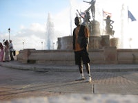 a man standing in front of a fountain